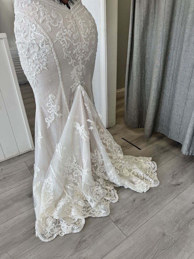 Altered white lace wedding gown with a beaded bodice and a long scalloped-lace train